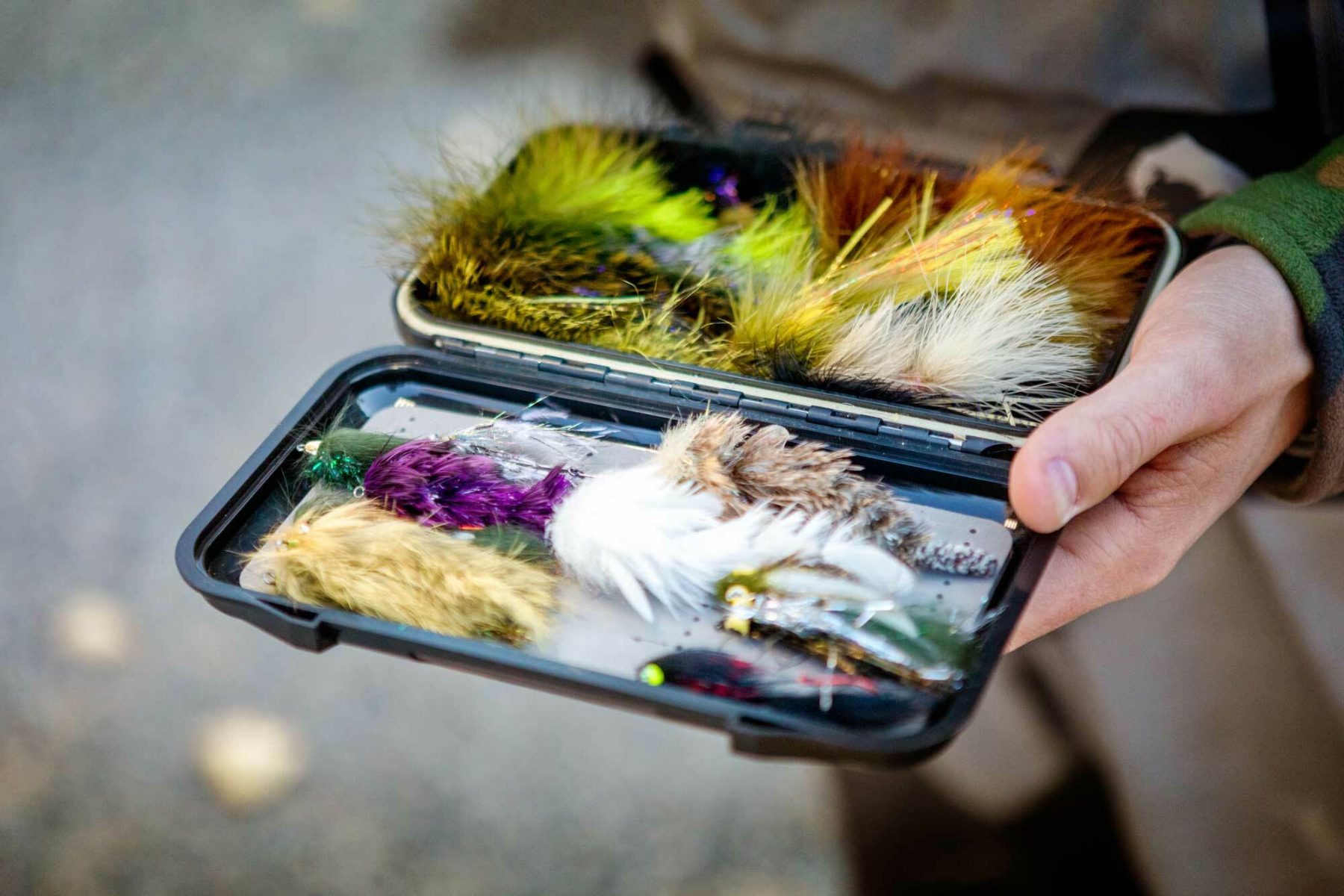 6182ba8536d91b716130de8a Bozeman Fly Supply Man Holding Flybox